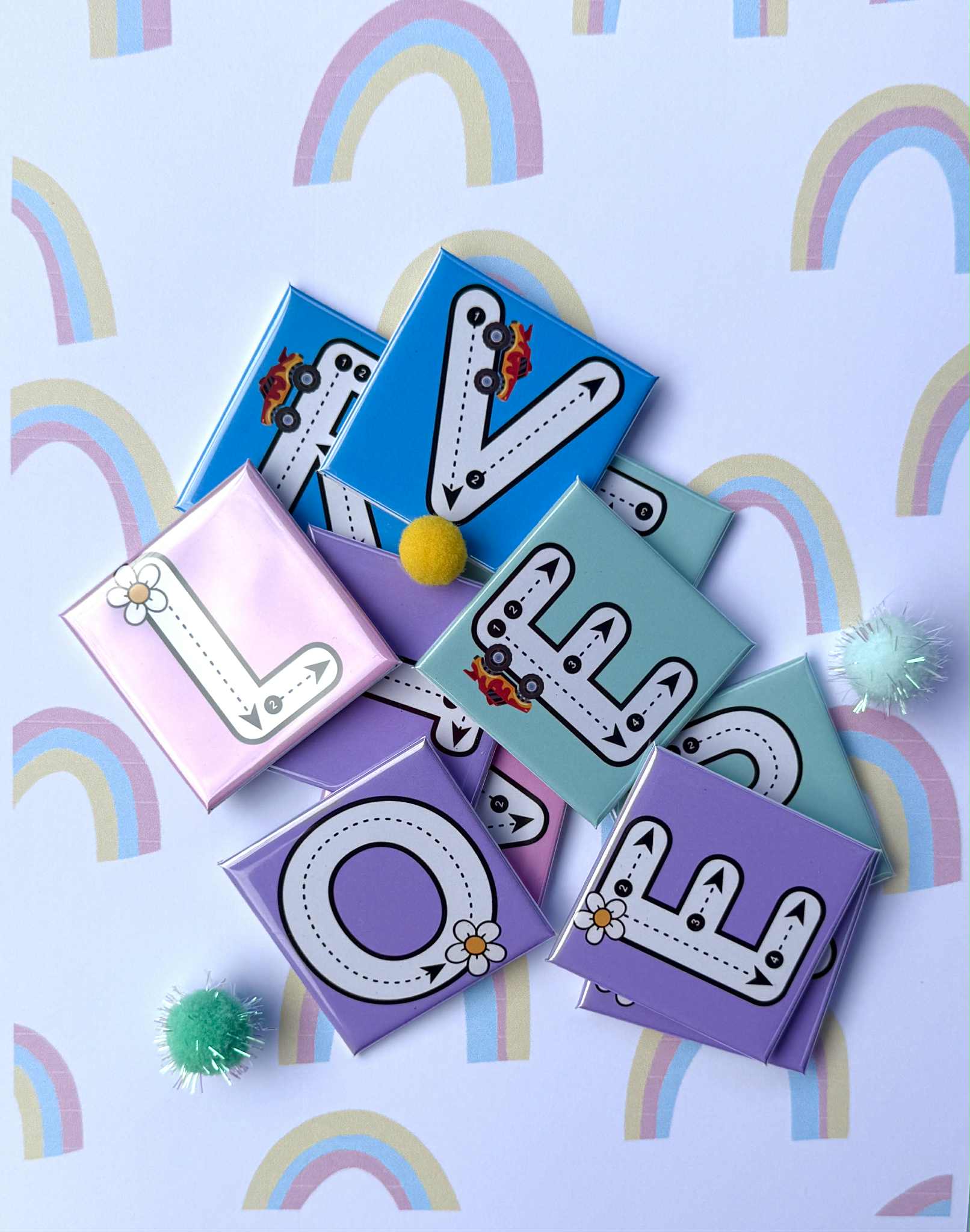 Colorful letter magnets spelling 'LOVE' on a background with rainbows