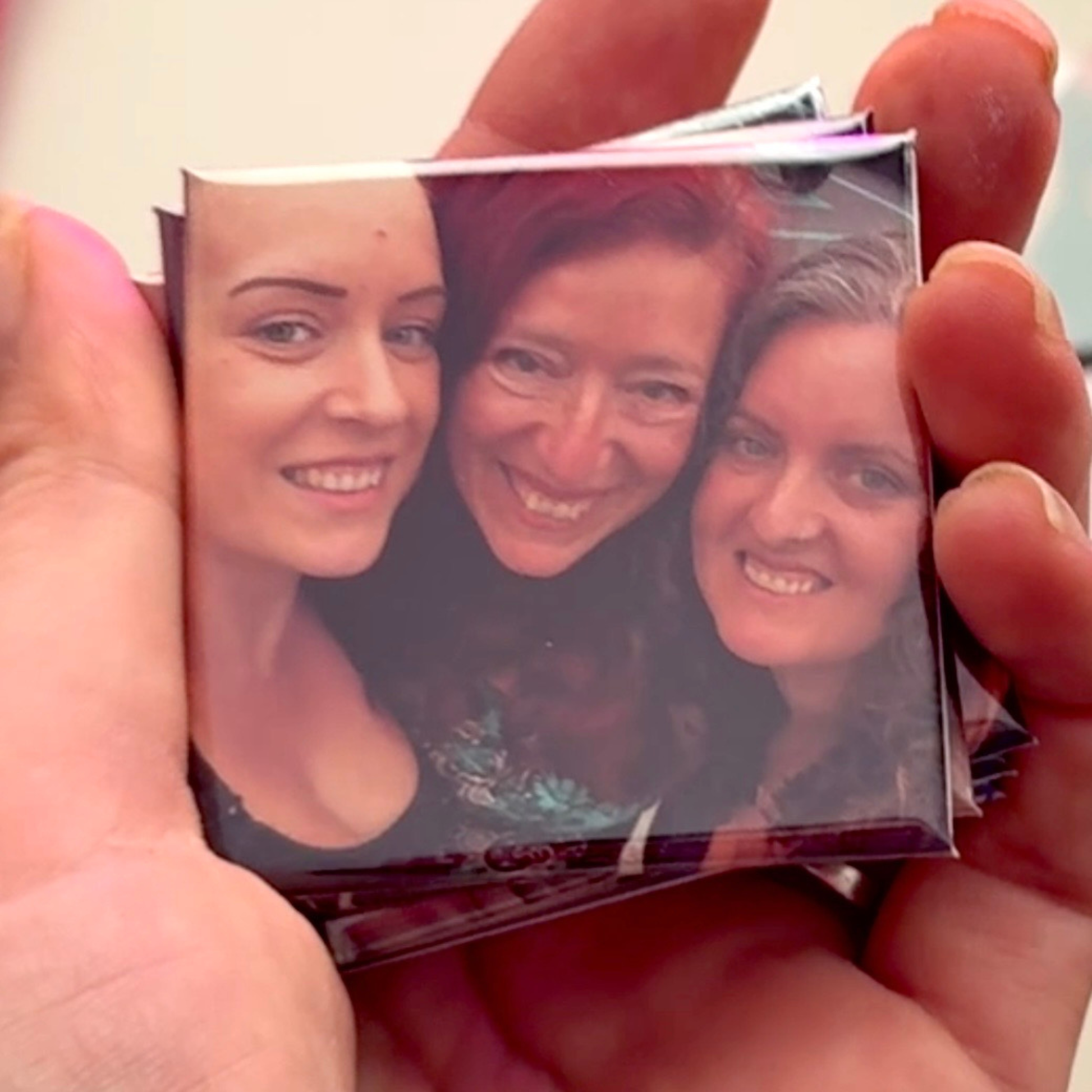 Hand holding a stack of personalised Mother's Day photo magnets featuring a mum and daughters, handmade in Australia