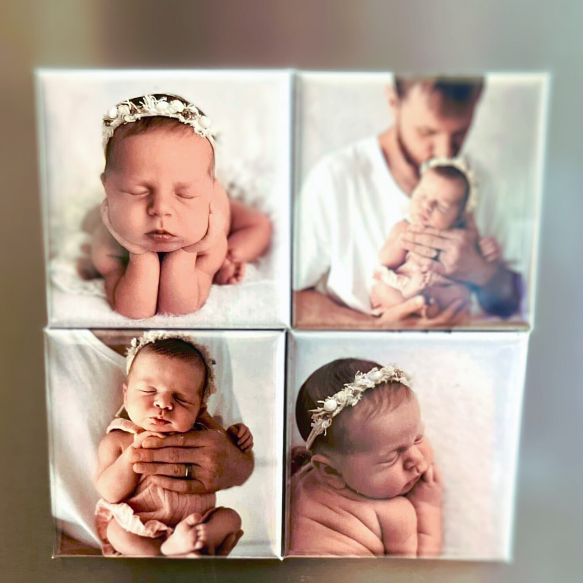 Set of four newborn photo magnets including close-ups of a sleeping baby girl wearing a floral headband, and a tender moment with her father.